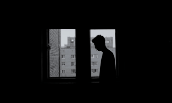 Person alone in front of window